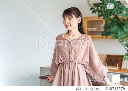 Middle-aged business woman in the kitchen or dining room Middle-aged business woman in the kitchen or dining room 140715579