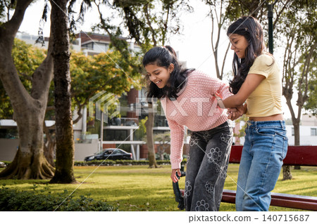Teen Sister Helping Younger Sister on Rollerblades in Park Teen Sister Helping Younger Sister on Rollerblades in Park 140715687