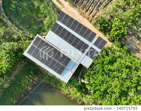 Rooftop solar panel installation on a rural farm building. Renewable energy generation, sustainable living and climate conscious infrastructure. Clean electricity production. Energy independence. 140715785