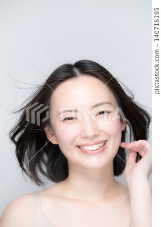 一位微笑的美麗女子,秀髮隨風飄揚;一張引人注目的美麗肖像,展現了她完美無瑕的肌膚和光澤亮麗的秀發,她面帶微笑,直視鏡頭。 一位微笑的美麗女子,秀髮隨風飄揚;一張引人注目的美麗肖像,展現了她完美無瑕的肌膚和光澤亮麗的秀發,她面帶微笑,直視鏡頭。 140716195