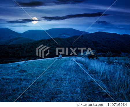 rural field on the hill at night. view in to the valley. countryside mountain landscape. full moon over alpine pasture near forested hills. inner strength to overcome fear, loneliness in darkness rural field on the hill at night. view in to the valley. countryside mountain landscape. full moon over alpine pasture near forested hills. inner strength to overcome fear, loneliness in darkness 140716984