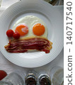 A simple breakfast plate with fried eggs and bacon. 140717540