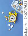 Pills and supplement with alarm clock and pill box on blue backgroun 140717621