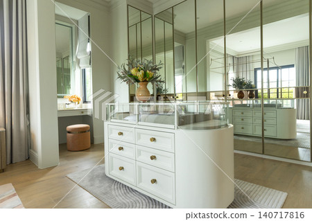 Luxury modern walk-in closet with mirror cabinets facades and island console. Luxury modern walk-in closet with mirror cabinets facades and island console. 140717816