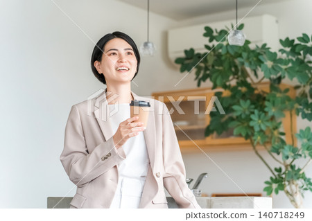 身著西裝的年輕亞洲女商人拿著一杯紙杯咖啡 身著西裝的年輕亞洲女商人拿著一杯紙杯咖啡 140718249