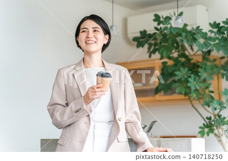 身著西裝的年輕亞洲女商人拿著一杯紙杯咖啡 身著西裝的年輕亞洲女商人拿著一杯紙杯咖啡 140718250