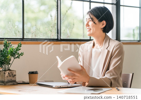 Young Asian woman reading a book in a cafe (self-development) Young Asian woman reading a book in a cafe (self-development) 140718551
