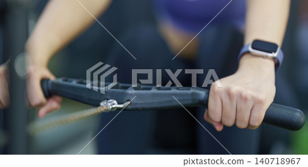 Cropped hands holding rowing machine handle for gym workout and strength training Cropped hands holding rowing machine handle for gym workout and strength training 140718967
