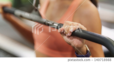 Cropped shot of woman gripping lat pulldown bar in gym for strength training Cropped shot of woman gripping lat pulldown bar in gym for strength training 140718988