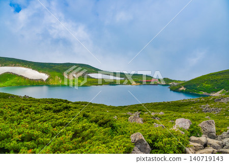 Summer in the Northern Alps: The mystical landscape of Lake Hakuba-Oike emerges from between the rising clouds. Summer in the Northern Alps: The mystical landscape of Lake Hakuba-Oike emerges from between the rising clouds. 140719143