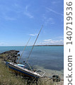 Sailboat on rocky seashore photo with blue sea, clear sky and coastal horizon, peaceful summer travel landscape for sailing, seaside vacation, tourism, nature and marine outdoor design 140719536
