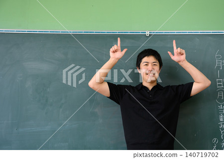 A school teacher pointed in front of the blackboard. A school teacher pointed in front of the blackboard. 140719702