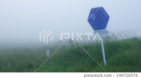 A sign on Hokkaido Prefectural Road 950 running through the Notsuke Peninsula in Betsukai Town, Hokkaido, amidst sea fog in summer. A sign on Hokkaido Prefectural Road 950 running through the Notsuke Peninsula in Betsukai Town, Hokkaido, amidst sea fog in summer. 140720578