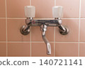 An old bathroom faucet covered in limescale 140721141