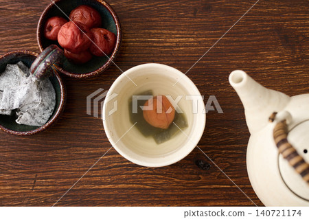Plum and kelp tea poured into a teacup Plum and kelp tea poured into a teacup 140721174