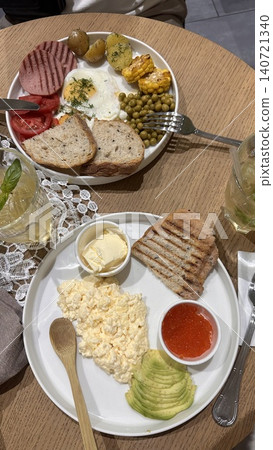 Healthy breakfast with scrambled eggs, avocado and red caviar on wooden table Healthy breakfast with scrambled eggs, avocado and red caviar on wooden table 140721340