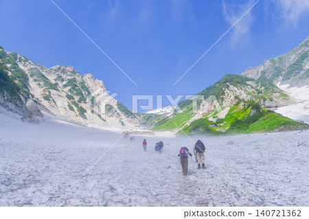 晴朗的夏日:一群登山者從白馬大雪谷的低處抬頭望去,雄偉的白馬岳在藍天的映襯下巍然聳立。 晴朗的夏日:一群登山者從白馬大雪谷的低處抬頭望去,雄偉的白馬岳在藍天的映襯下巍然聳立。 140721362