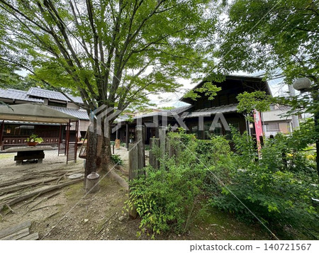 一座傳統的日式房屋和庭院,四周綠樹環繞。 一座傳統的日式房屋和庭院,四周綠樹環繞。 140721567