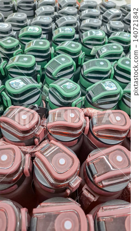 Rows of green and dark pink reusable water bottles close up Rows of green and dark pink reusable water bottles close up 140721842