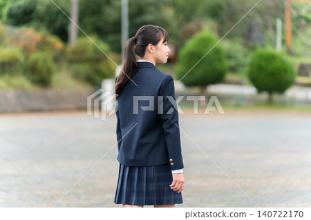 Back view of junior high school, high school, and elementary school students in uniform standing in front of a school building Back view of junior high school, high school, and elementary school students in uniform standing in front of a school building 140722170