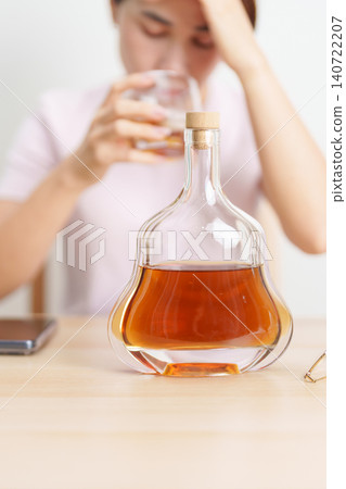 Stressed woman drinking cognac alone with problem. Exhausted drunk man looking stressed and sleepy. Alcohol addiction, Alcoholism, emotional distress and mental health concept Stressed woman drinking cognac alone with problem. Exhausted drunk man looking stressed and sleepy. Alcohol addiction, Alcoholism, emotional distress and mental health concept 140722207