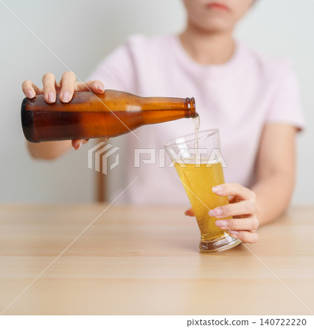 woman pour Beer into a glass on table, suffering from alcohol addiction, alcoholism concept. depicting emotional distress, depression, substance abuse problem, unhealthy lifestyle and mental health woman pour Beer into a glass on table, suffering from alcohol addiction, alcoholism concept. depicting emotional distress, depression, substance abuse problem, unhealthy lifestyle and mental health 140722220