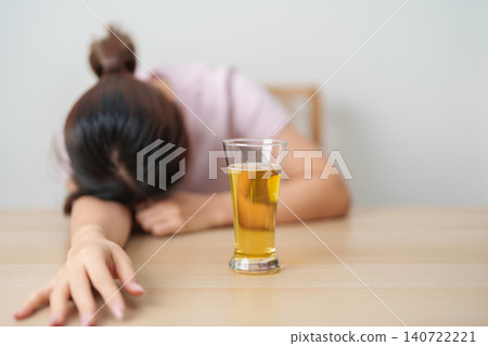 Stressed woman drinking beer alone with problem. Exhausted drunk woman looking stressed and sleepy. Alcohol addiction, Alcoholism, emotional distress and mental health concept Stressed woman drinking beer alone with problem. Exhausted drunk woman looking stressed and sleepy. Alcohol addiction, Alcoholism, emotional distress and mental health concept 140722221