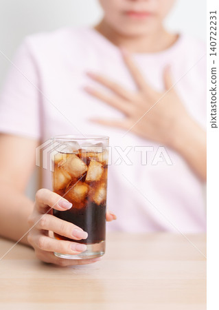 Woman hold stomach and feeling Abdominal pain after drinking carbonated soft drink, bloating and gas in digestive system, unhealthy beverage effect. stomach ache,  Acid reflux, Heartburn and Gastritis 140722231