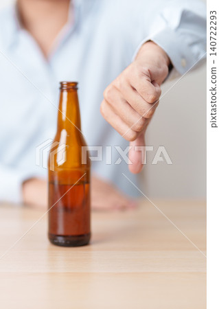 man show thumb down hand gesture to refuse a bottle of Beer, Healthy man say no to alcohol drink, stop alcoholism and addiction concept. Responsible man reject a drink before driving and quit booze man show thumb down hand gesture to refuse a bottle of Beer, Healthy man say no to alcohol drink, stop alcoholism and addiction concept. Responsible man reject a drink before driving and quit booze 140722293