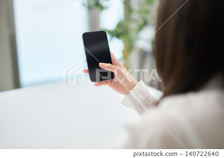 A woman in her 20s looking at her smartphone. A woman in her 20s looking at her smartphone. 140722640