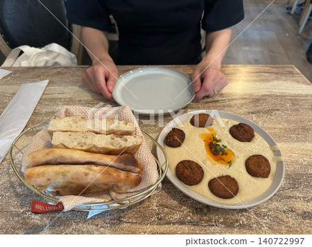 A traditional Middle Eastern appetizer plate featuring hummus, falafel, and pita bread. 140722997