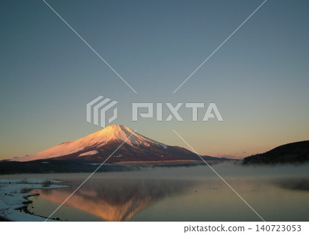 在一個晴朗的清晨,山中湖沐浴在晨曦之中,富士山隱約可見。 在一個晴朗的清晨,山中湖沐浴在晨曦之中,富士山隱約可見。 140723053