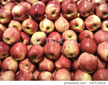 Full frame background of fresh organic red apples piled on display at a supermarket or grocery store produce section. 140723629
