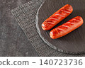 two grilled sausages on slate panel, selective focus 140723736