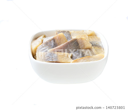 pieces of herring fillet on a white bowl isolated on a white background. pieces of herring fillet on a white bowl isolated on a white background. 140723801