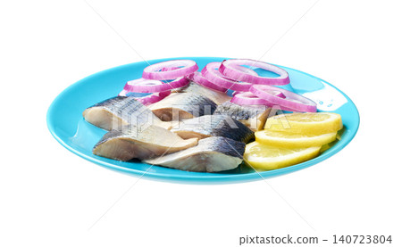 pieces of herring fillet with red onion rings and lemon on a blue plate isolated on a white background. pieces of herring fillet with red onion rings and lemon on a blue plate isolated on a white background. 140723804