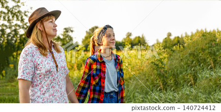 portrait of mature mother and teenage daughter outdoors, country lifestyle, family relationship and eco tourism concept. A warm and authentic portrait of a mother and teenage daughter portrait of mature mother and teenage daughter outdoors, country lifestyle, family relationship and eco tourism concept. A warm and authentic portrait of a mother and teenage daughter 140724412