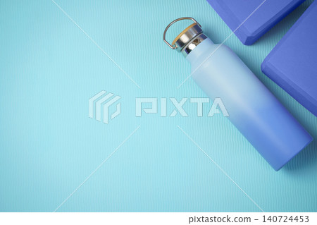 Blue Reusable Water Bottle With Yoga Blocks On Textured Yoga Mat For Fitness And Hydration Blue Reusable Water Bottle With Yoga Blocks On Textured Yoga Mat For Fitness And Hydration 140724453