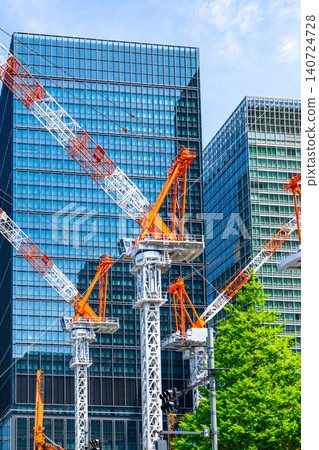 Large cranes and skyscrapers at a construction site 140724728