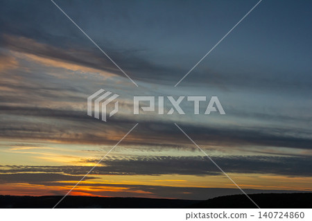 Dramatic sunset with colorful clouds over a vast landscape showcasing the beauty of nature during twilight hours Dramatic sunset with colorful clouds over a vast landscape showcasing the beauty of nature during twilight hours 140724860