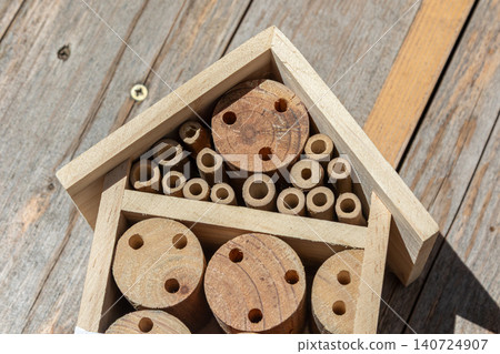 Crafted wooden pieces arranged inside a small wooden house structure on a rustic wooden surface showcasing creativity and craftsmanship Crafted wooden pieces arranged inside a small wooden house structure on a rustic wooden surface showcasing creativity and craftsmanship 140724907