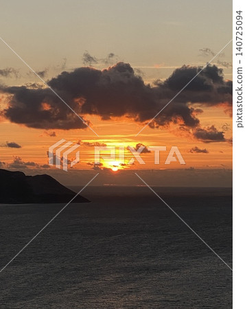 Dramatic sunset over ocean with clouds and distant silhouette of island, perfect for background Dramatic sunset over ocean with clouds and distant silhouette of island, perfect for background 140725094