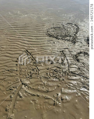 Cute drawing of a cat and a heart drawn on wet sand at low tide. Textured coast, children's creativity, romantic 140725178