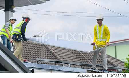 Solar Panel Installation Workers on Residential Rooftop Wearing Safety Helmets and High-Visibility Vests Solar Panel Installation Workers on Residential Rooftop Wearing Safety Helmets and High-Visibility Vests 140725306