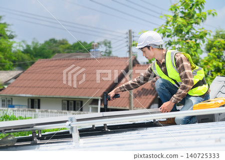 Solar Panel Installer Technician Working on Rooftop with Power Drill and Safety Equipment Solar Panel Installer Technician Working on Rooftop with Power Drill and Safety Equipment 140725333
