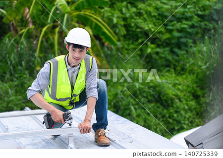 Asian Technician Installing Solar Panel on Rooftop with Power Drill Wearing Safety Vest and Helmet Asian Technician Installing Solar Panel on Rooftop with Power Drill Wearing Safety Vest and Helmet 140725339
