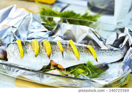 Marinated trout with herbs and lemon on foil before baking. Marinated trout with herbs and lemon on foil before baking. 140725569