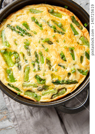Healthy Asparagus and Herb Frittata closeup in the skillet on the table. Vertical top view Healthy Asparagus and Herb Frittata closeup in the skillet on the table. Vertical top view 140725619