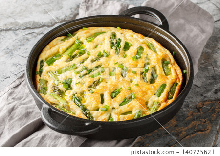 Homemade baked vegetable frittata with green asparagus closeup in the skillet. Horizontal 140725621