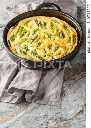 Healthy Asparagus and Herb Frittata closeup in the skillet on the table. Vertical Healthy Asparagus and Herb Frittata closeup in the skillet on the table. Vertical 140725623